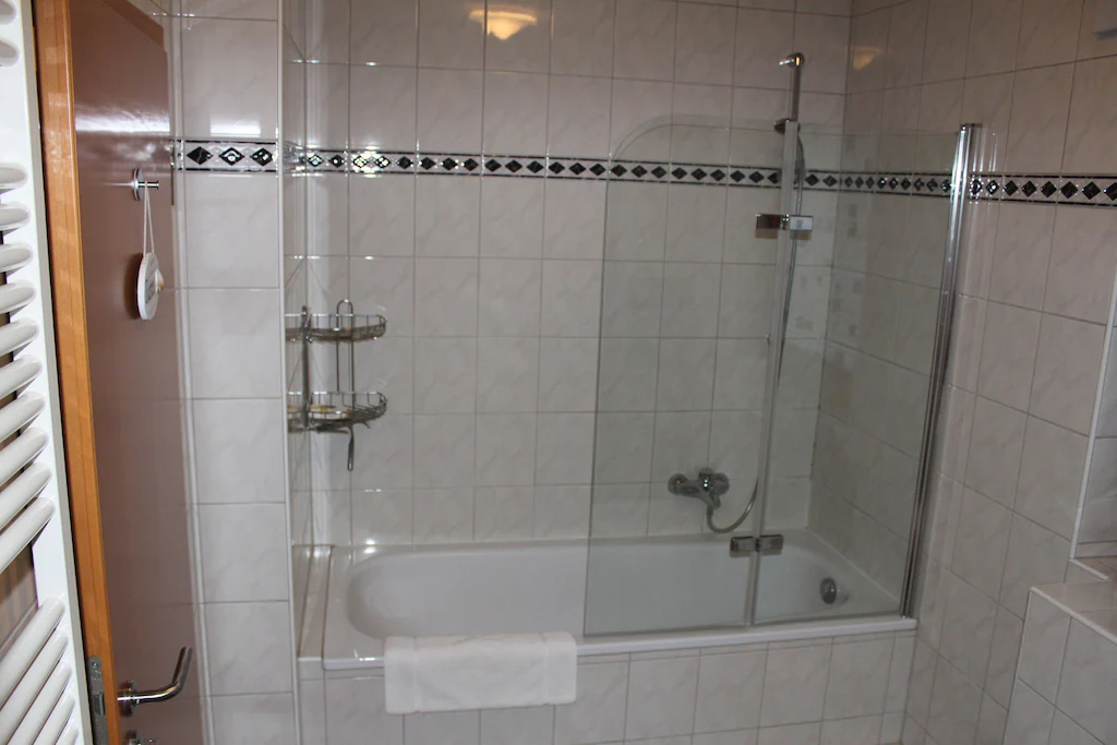 Badezimmer mit Badewanne und Duschwand